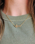 4K gold-filled personalized cross necklace engraved with the name Katlyn on a model’s neck