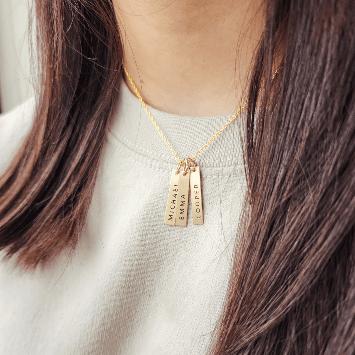 Minimalist 14k gold-filled vertical bar necklace with personalized engraved name in uppercase block font