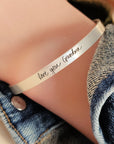 silver cuff bracelet on arm stating love you grandma
