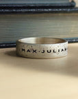 Silver ring with 'MAX JULIAN' engraving on a textured surface