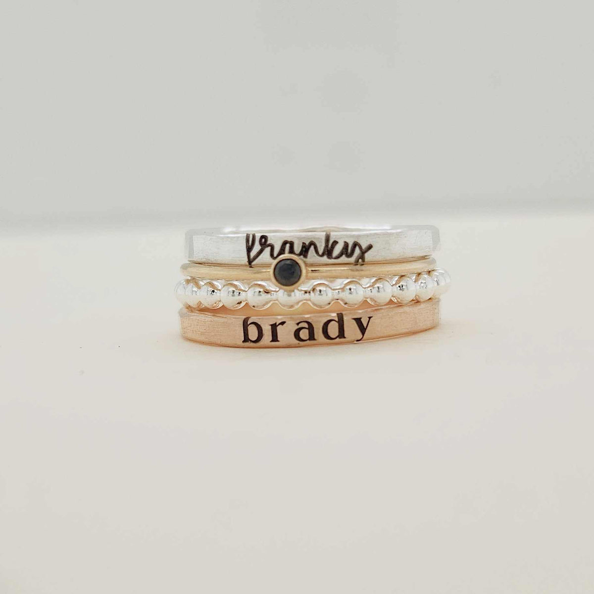 The Maisie stacking name ring set with personalized names, birthstone, and beaded silver ring