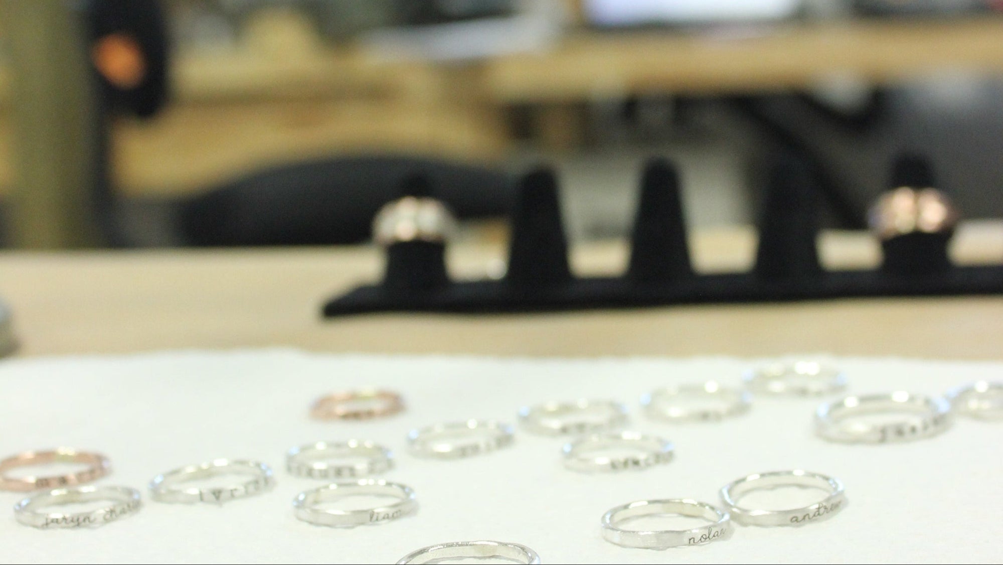Close-up of gold rings on a white surface with a blurred office background