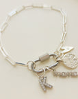 Silver bracelet with charms on a light beige background