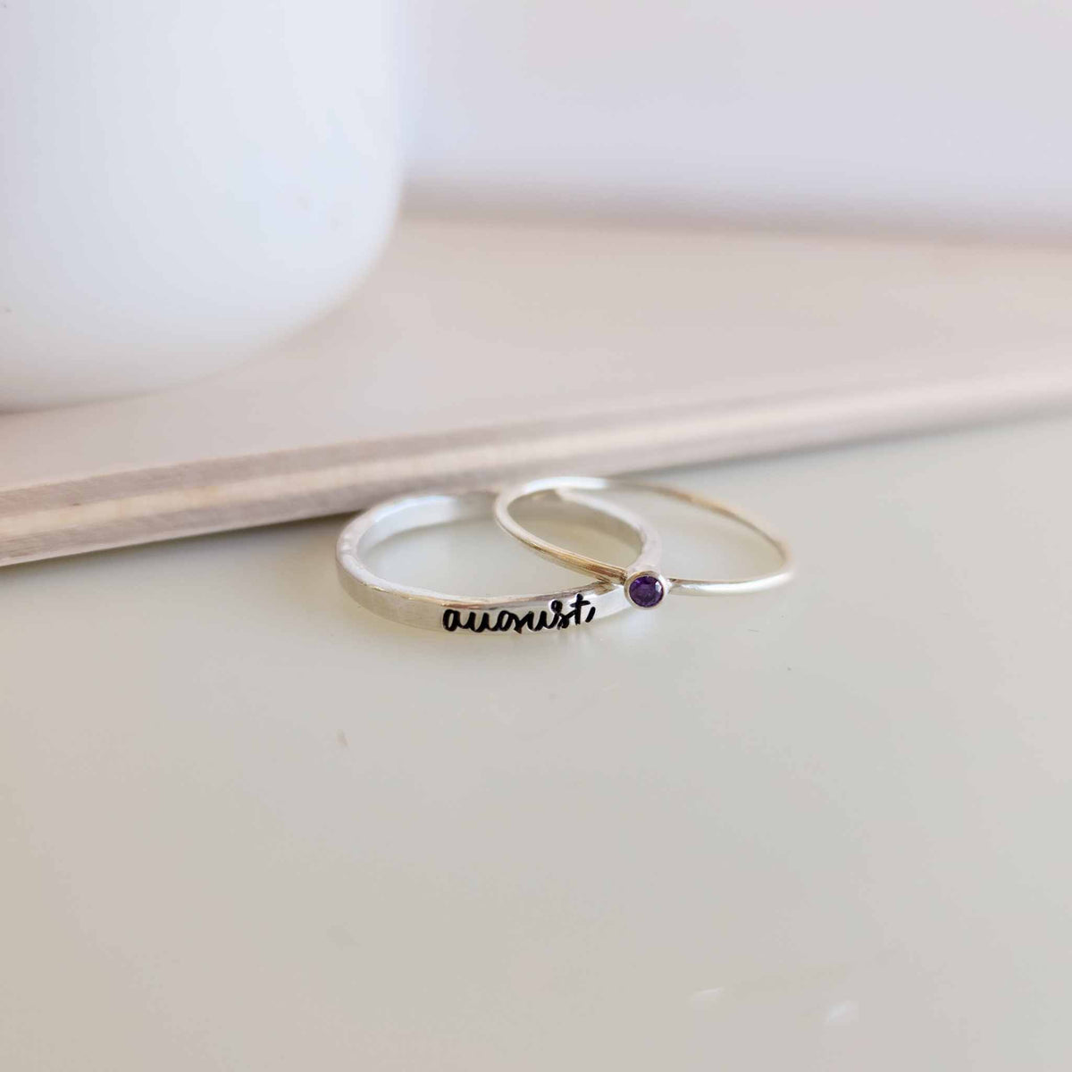 A photo showing a gold-colored ring with the name 'Charlie' engraved on it, worn on a person's finger.
