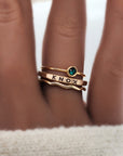 A set of three golden rings, featuring a birthstone, a name ring, and a wavy ring