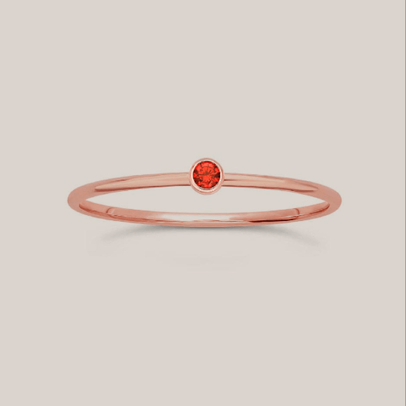 Delicate 14K rose gold filled July birthstone ring with 1mm slim band and 2mm ruby-colored crystal for stacking or everyday wear