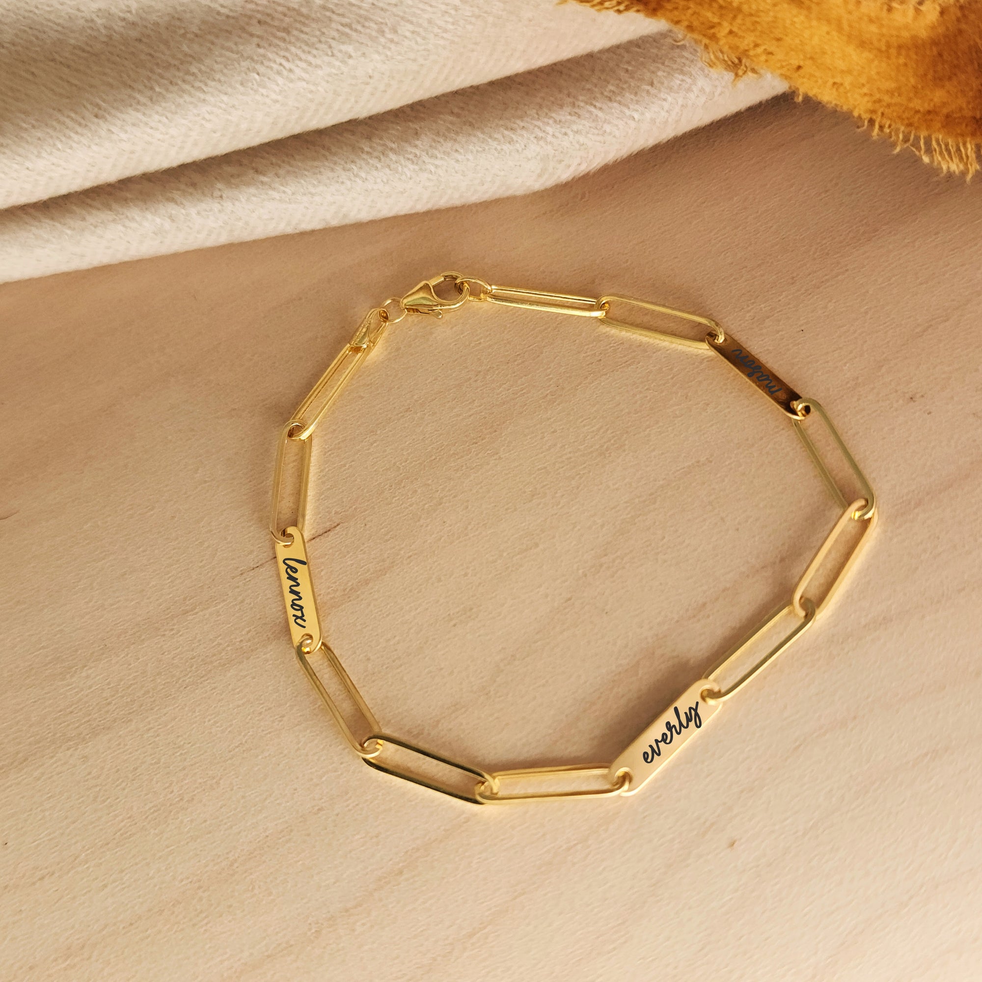 14K solid gold engravable bracelet styled with cream and mustard fabric for a cozy look