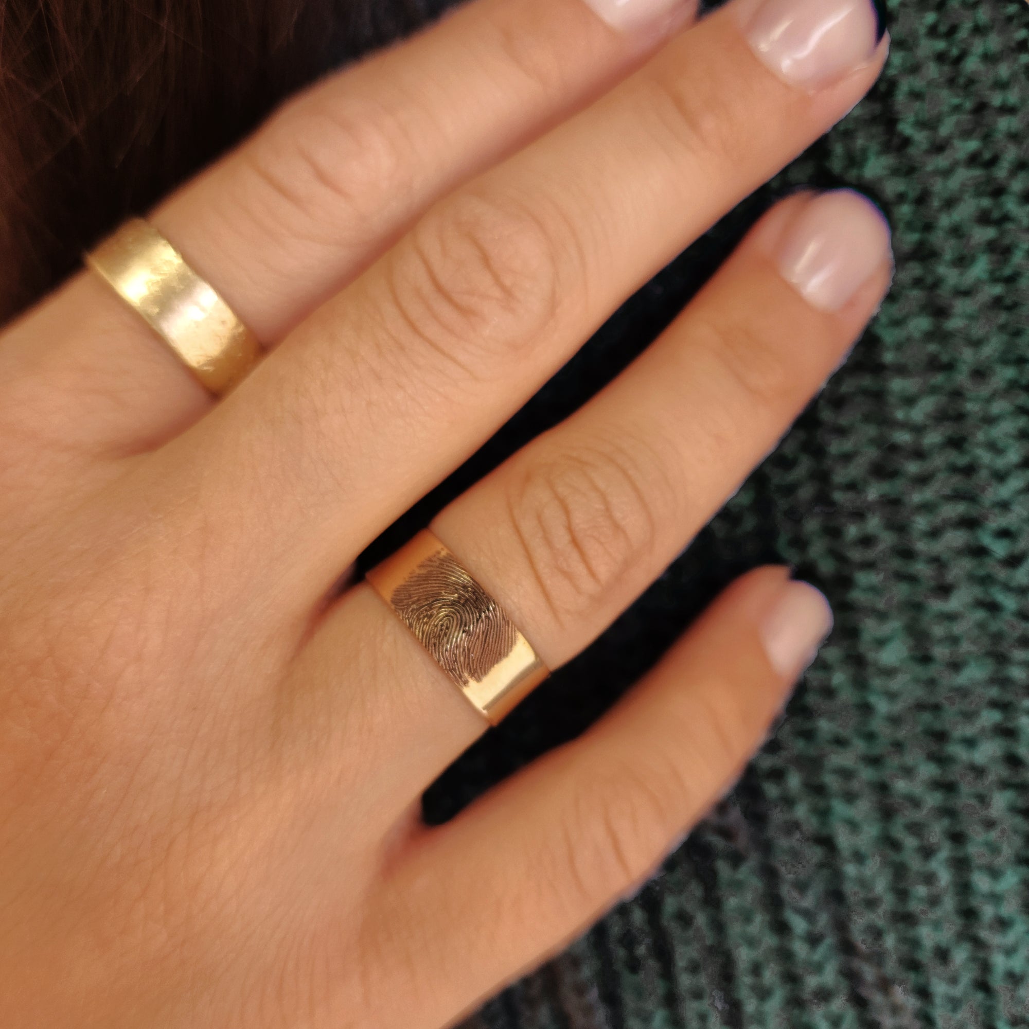 14K solid gold fingerprint band worn on hand with green sweater