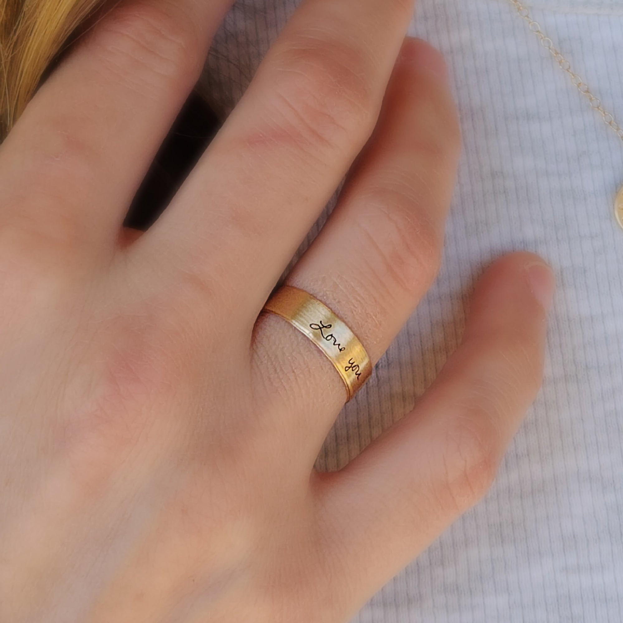 Woman wearing 14K solid gold handwriting ring on finger, showing engraved message