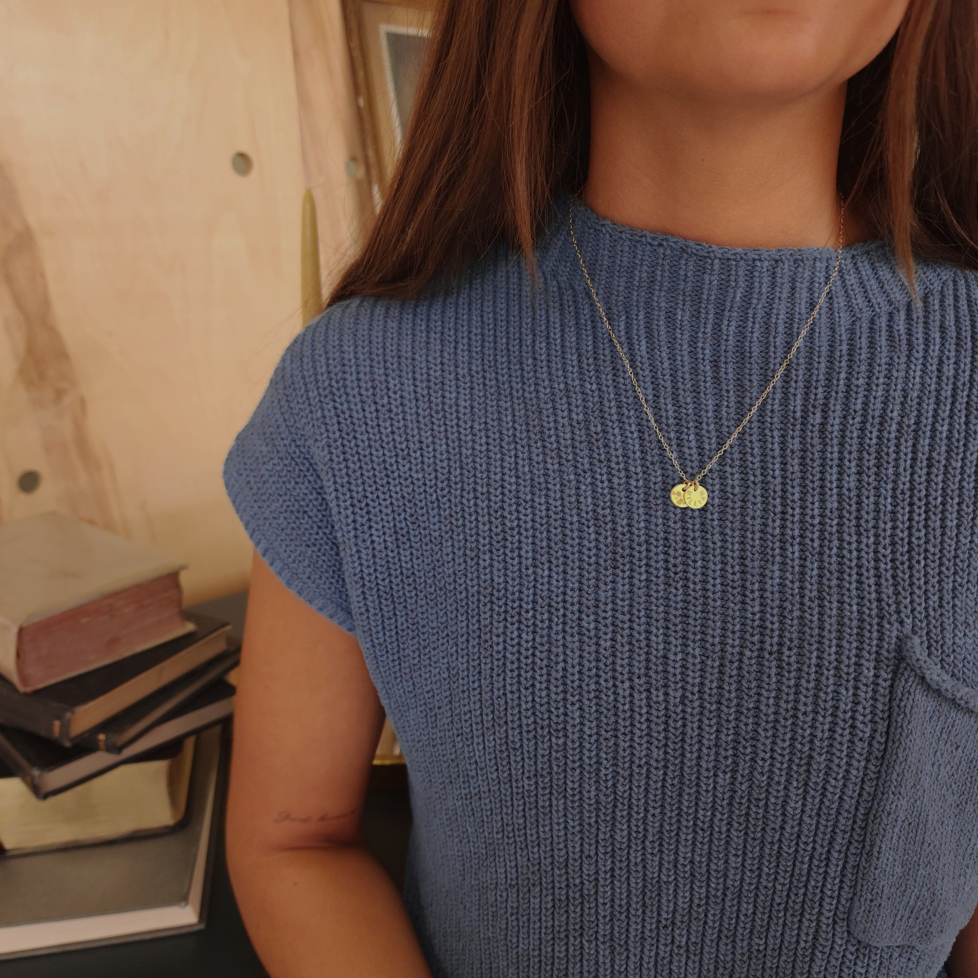 14K solid gold name necklace styled over soft blue ribbed knit top