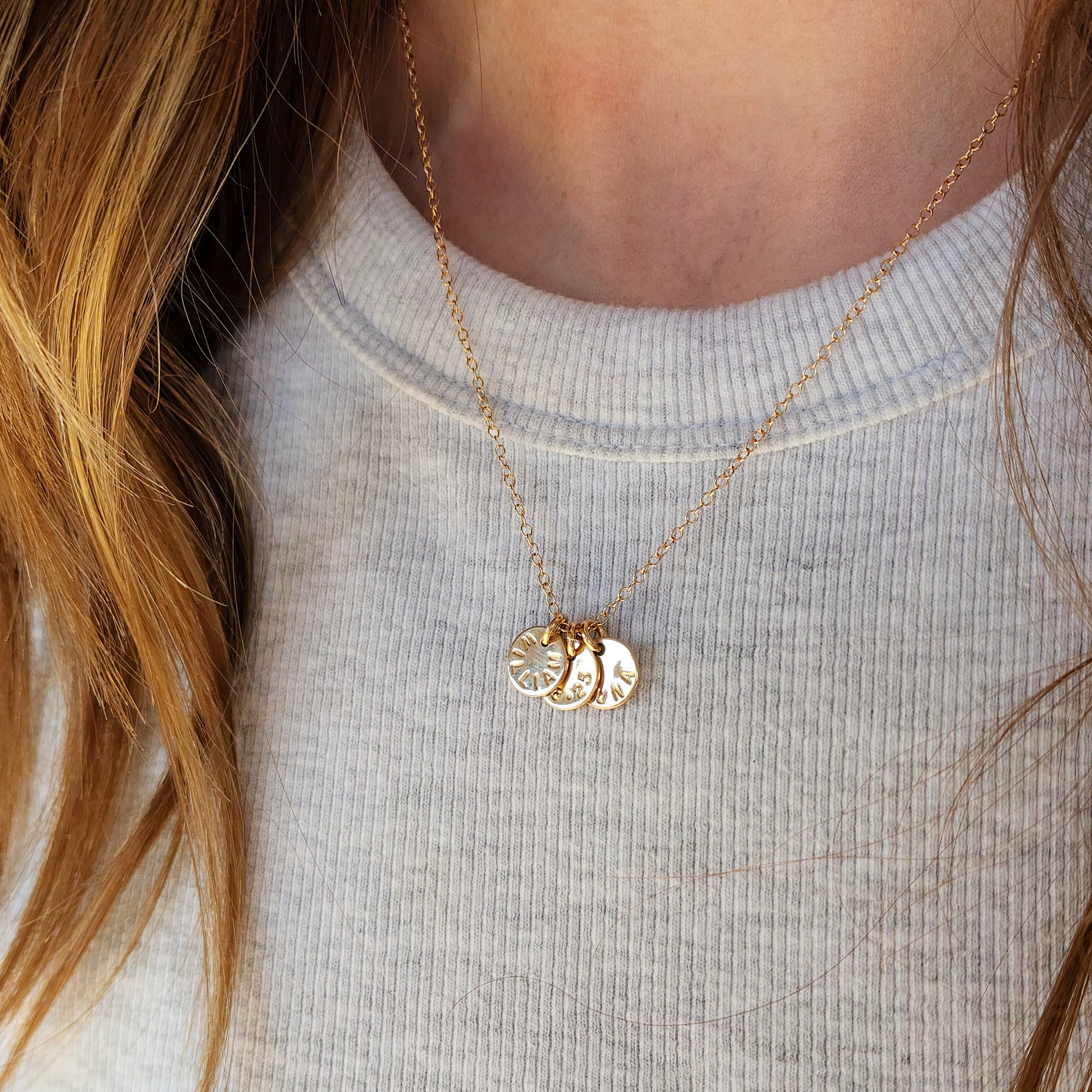 Close-up of woman wearing 14K solid gold name necklace with three personalized tags