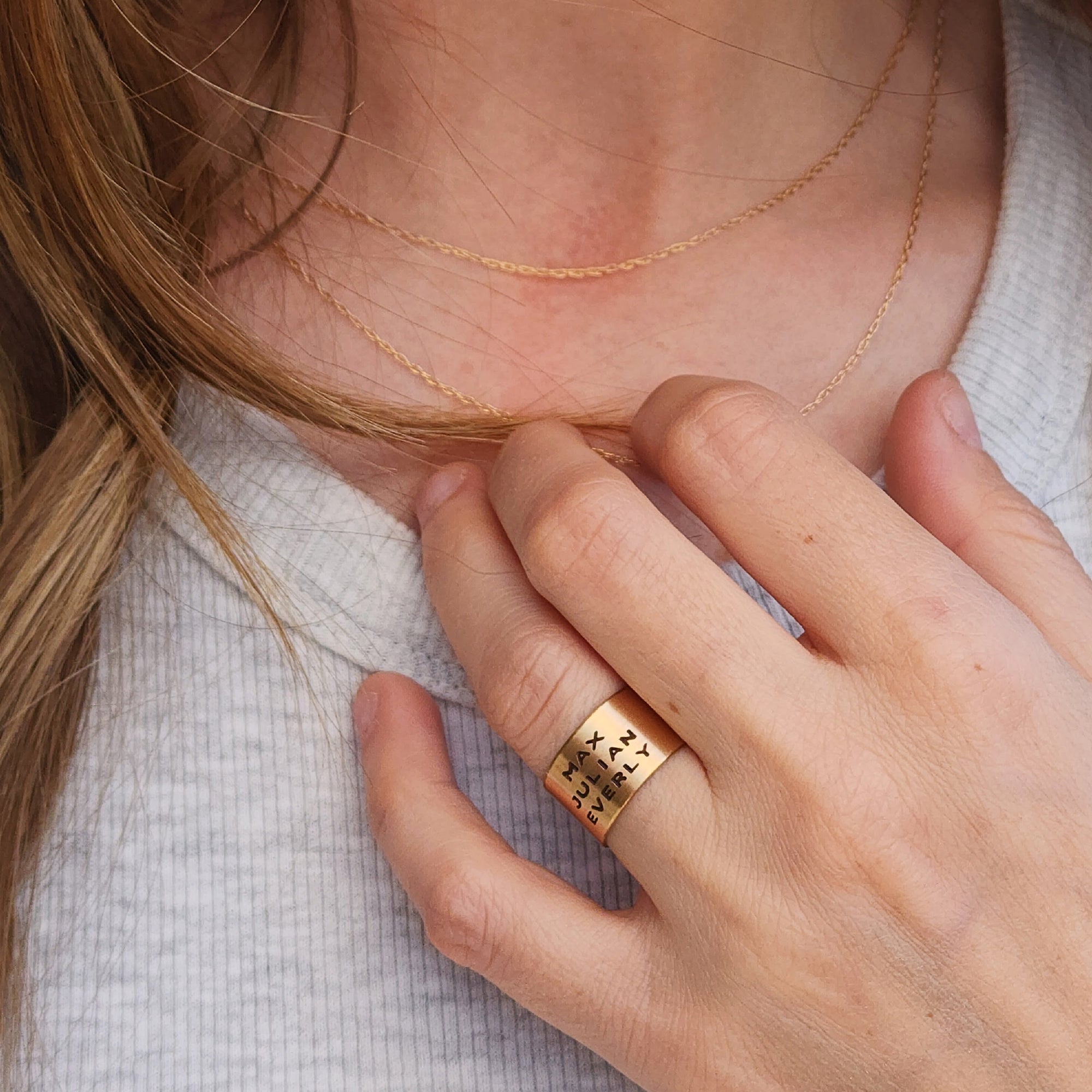 Model wearing 14K solid gold personalized band with engraved names on wide gold ring