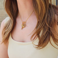 Model wearing 18k gold plated PVD add-on charms on gold chain necklace with butterfly and heart charms