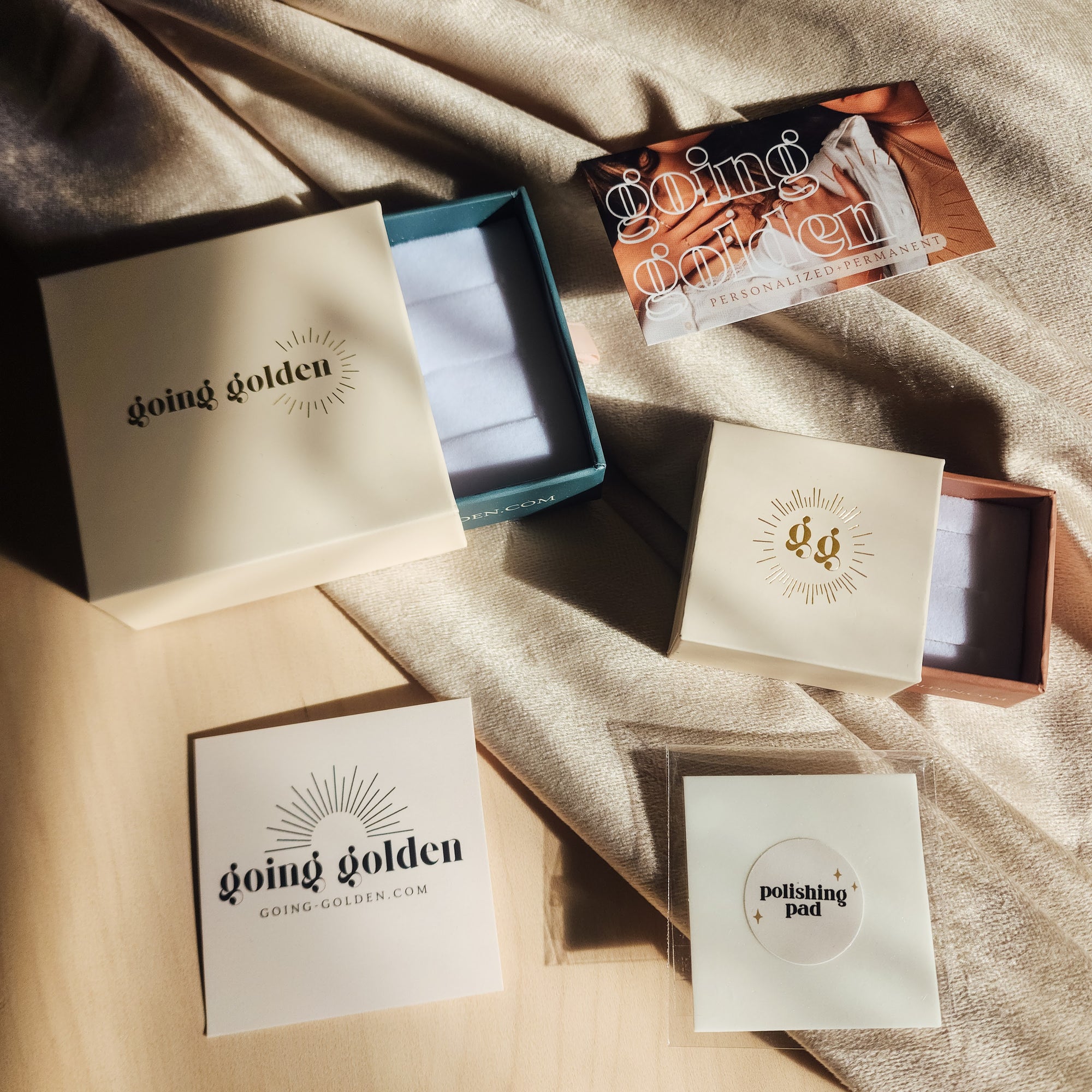 18k gold plated PVD add-on charms displayed with Going Golden gift boxes and packaging