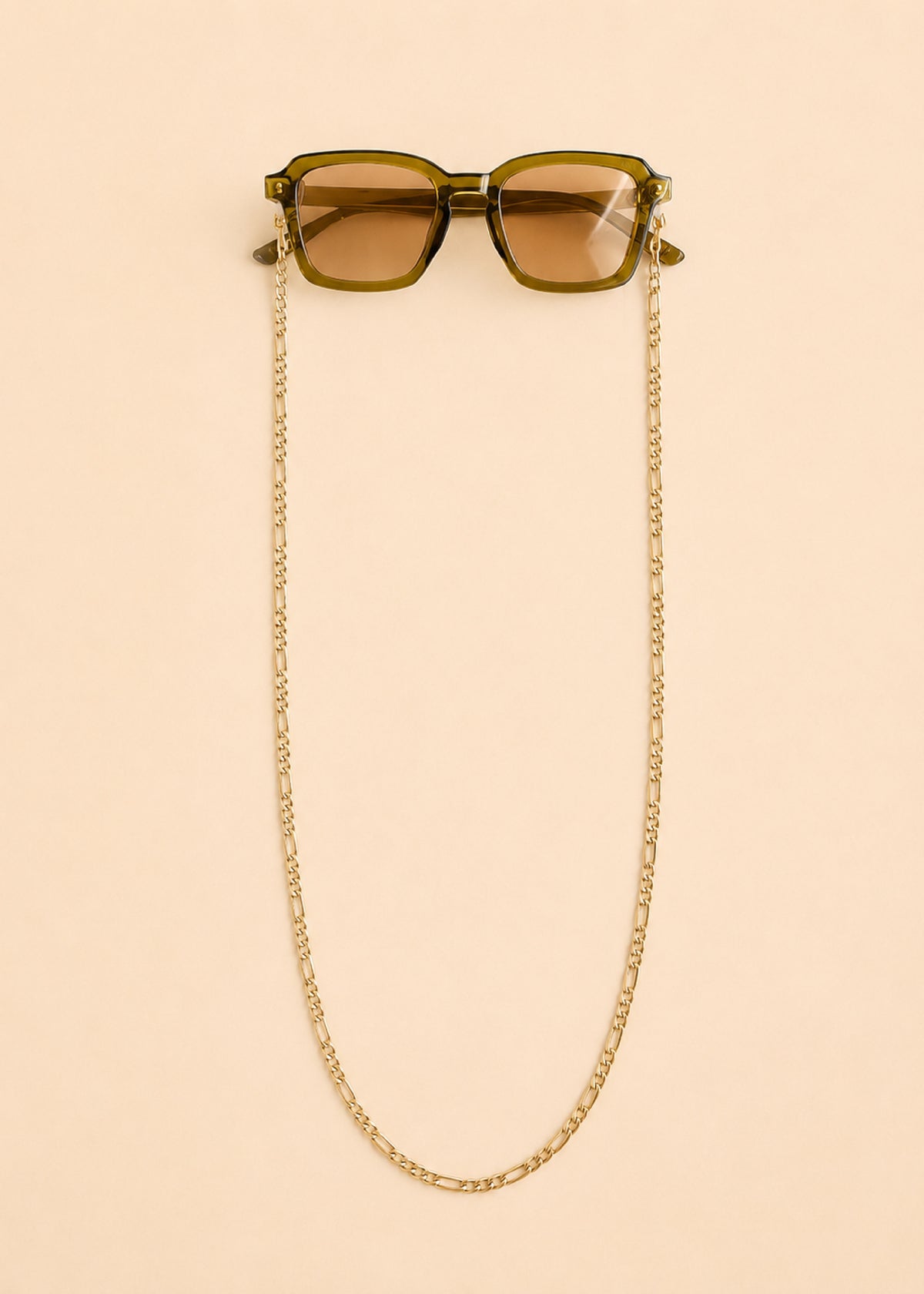 Sunglasses with a gold chain on a beige background