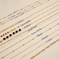 Gold necklaces with different names on a beige background