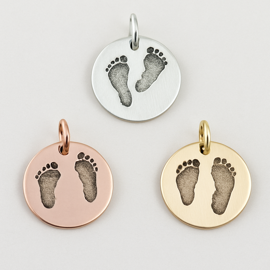 Three round pendants with footprints in silver, rose gold, and yellow gold on a light gray background.