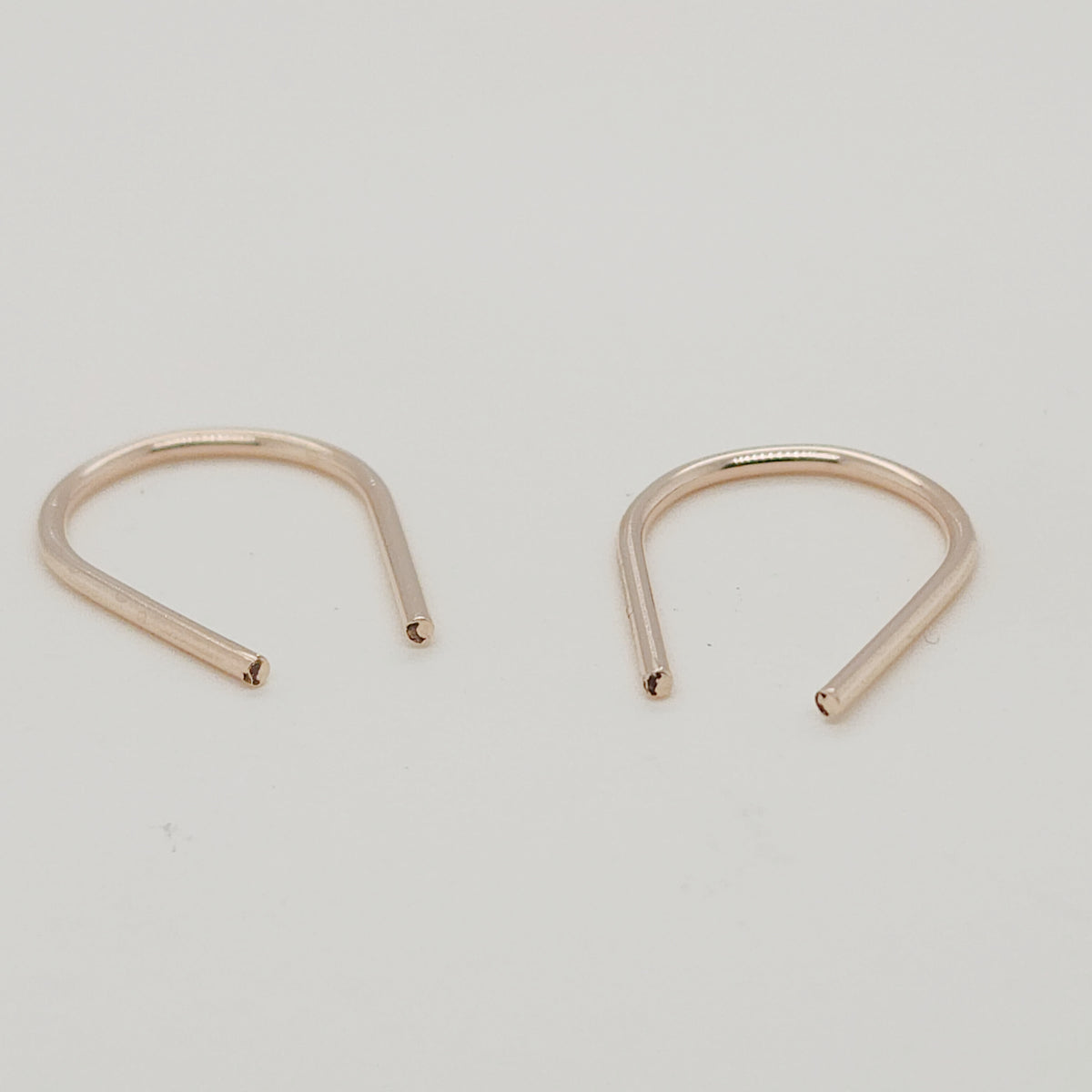 Angled view of gold U-shaped earrings for modern jewelry styling