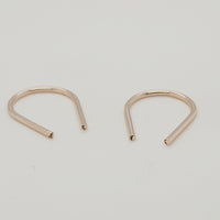 Angled view of gold U-shaped earrings for modern jewelry styling