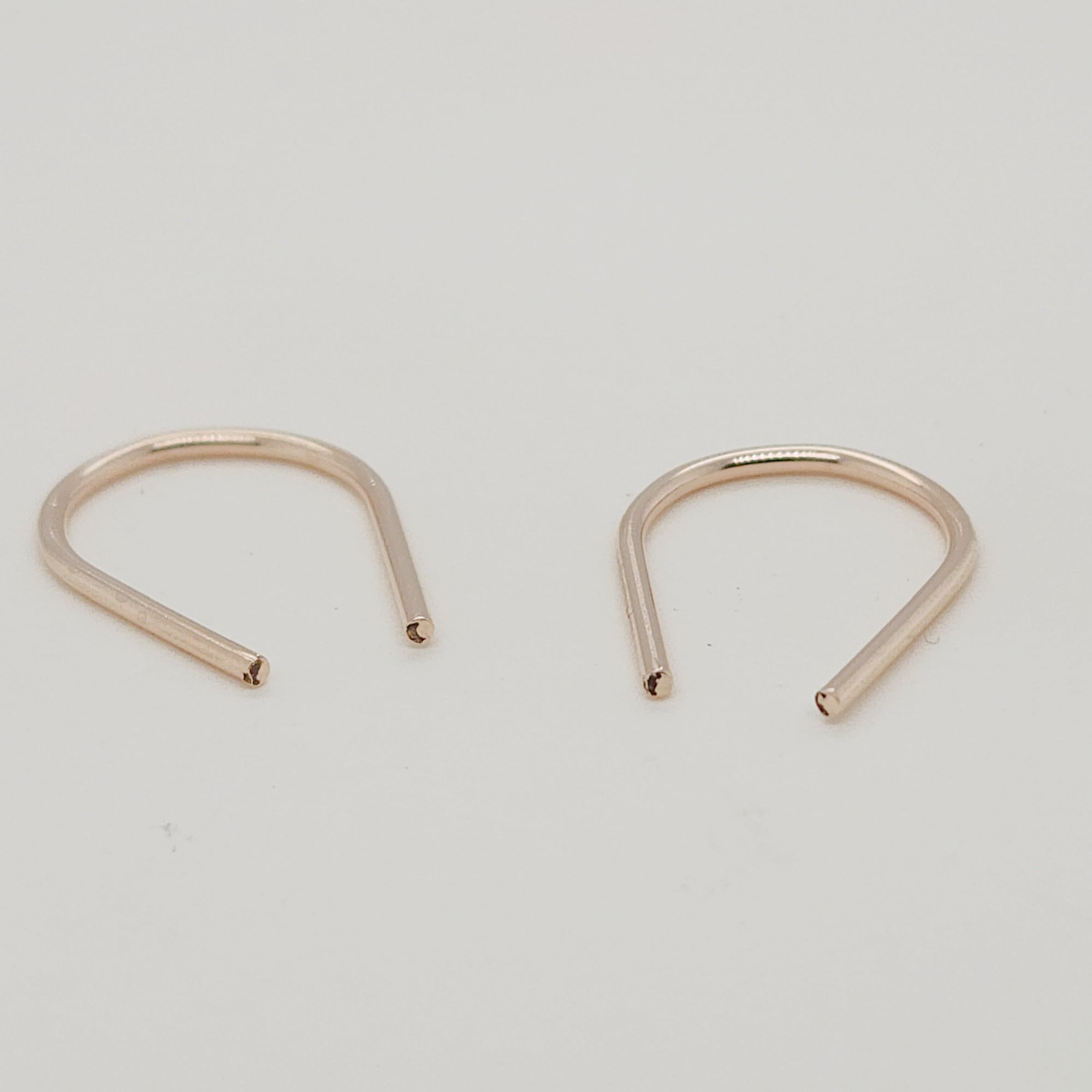Angled view of gold U-shaped earrings for modern jewelry styling