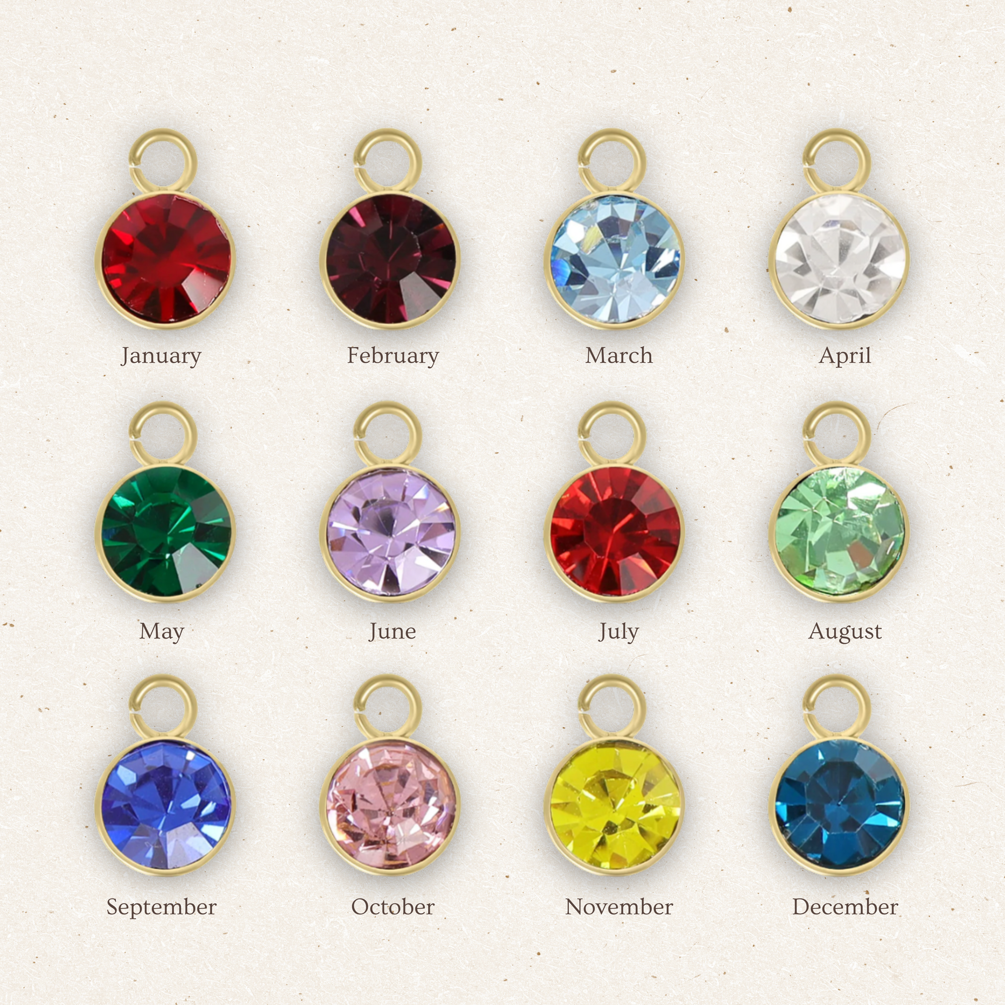 Colorful gemstone charms with gold frames for each month of the year on a white background.