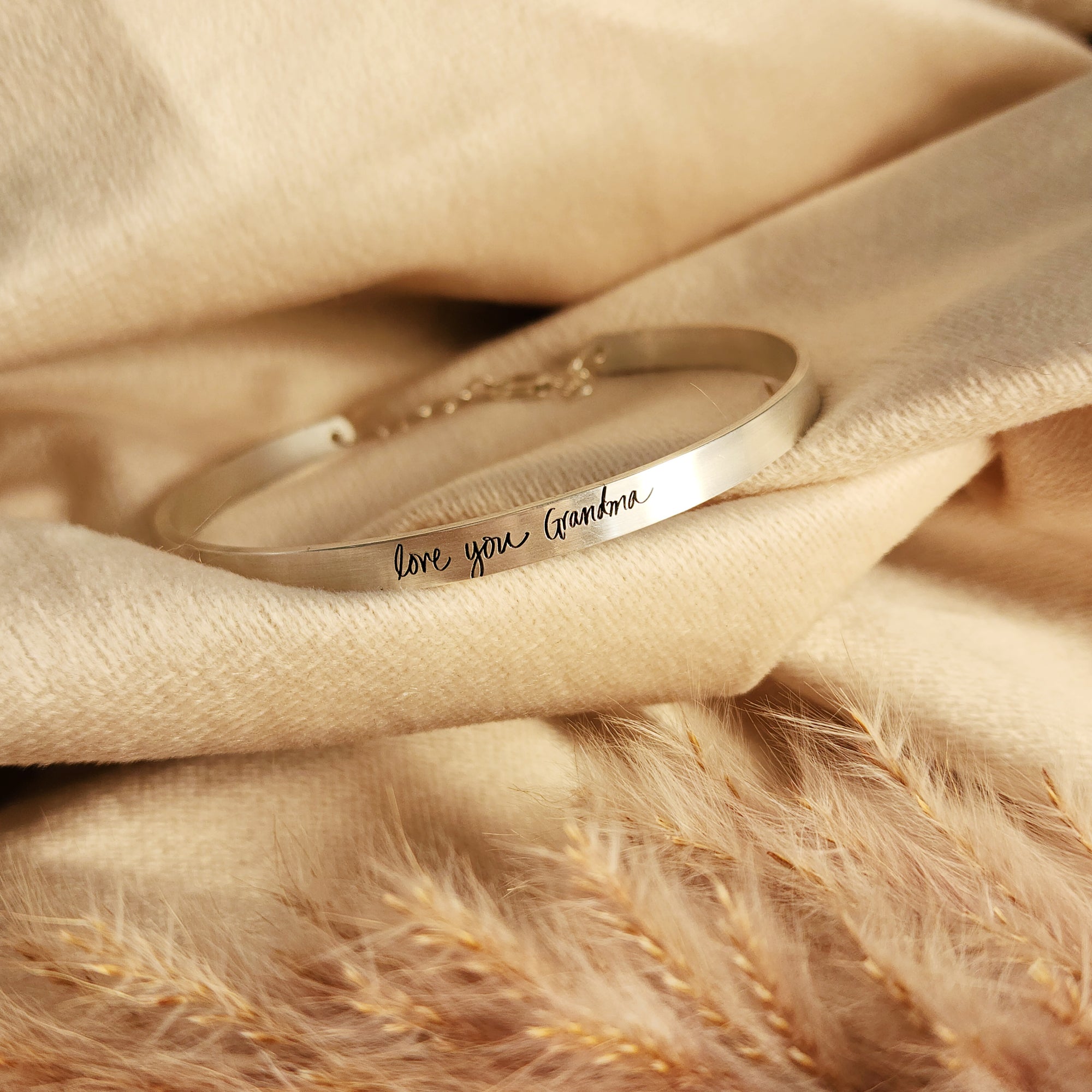 silver cuff bracelet laying on beige materal