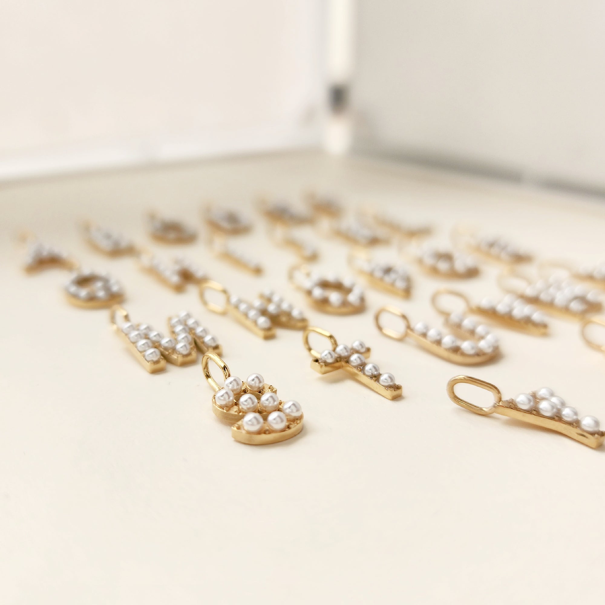 Gold and pearl necklace on a light beige surface