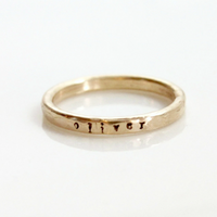 Single 14k gold-filled name ring stamped with small font saying a kid's name