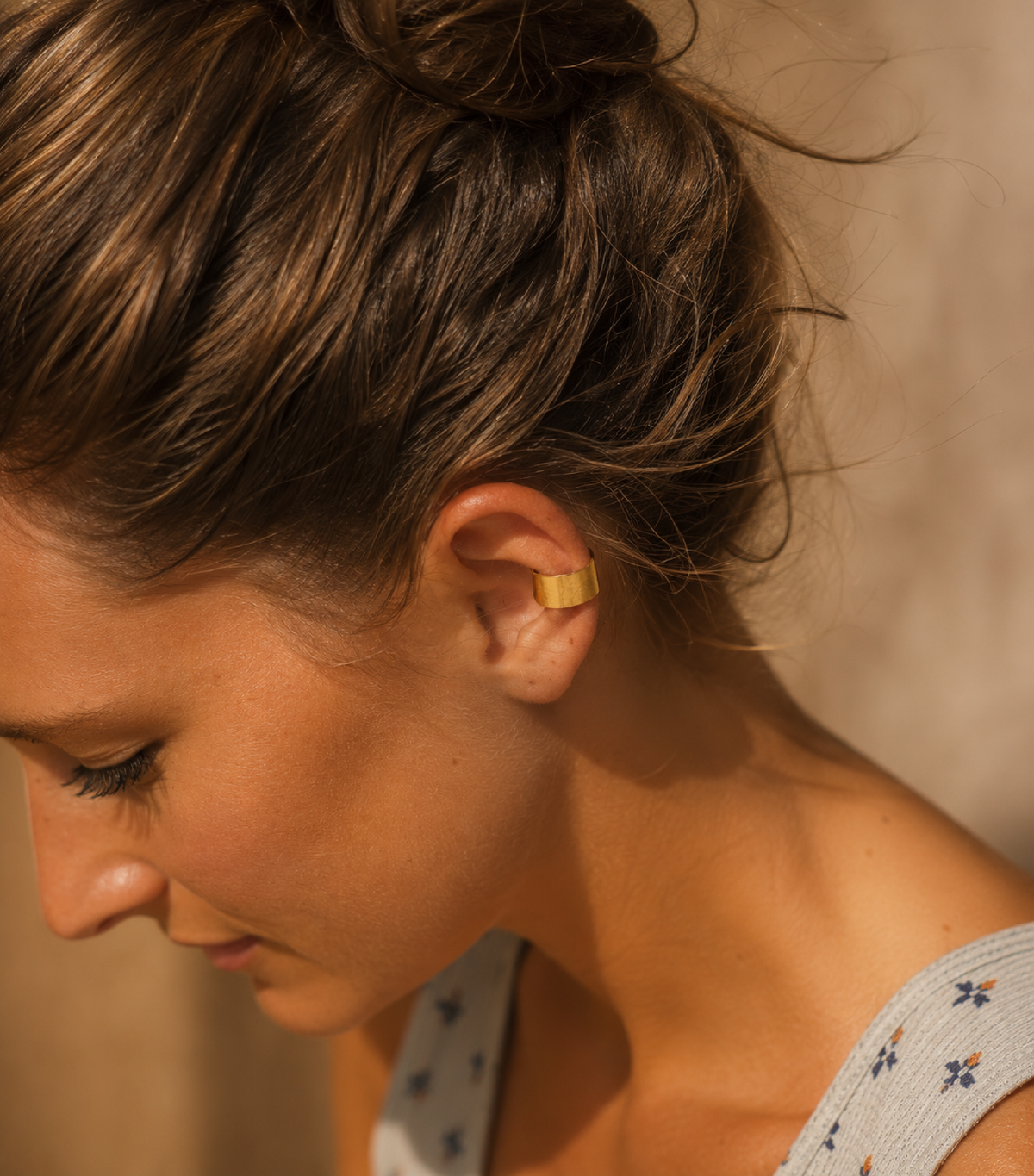 Woman wearing a wide 14K gold-filled ear cuff with no piercing required.