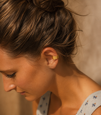 Woman wearing a wide 14K gold-filled ear cuff with no piercing required.
