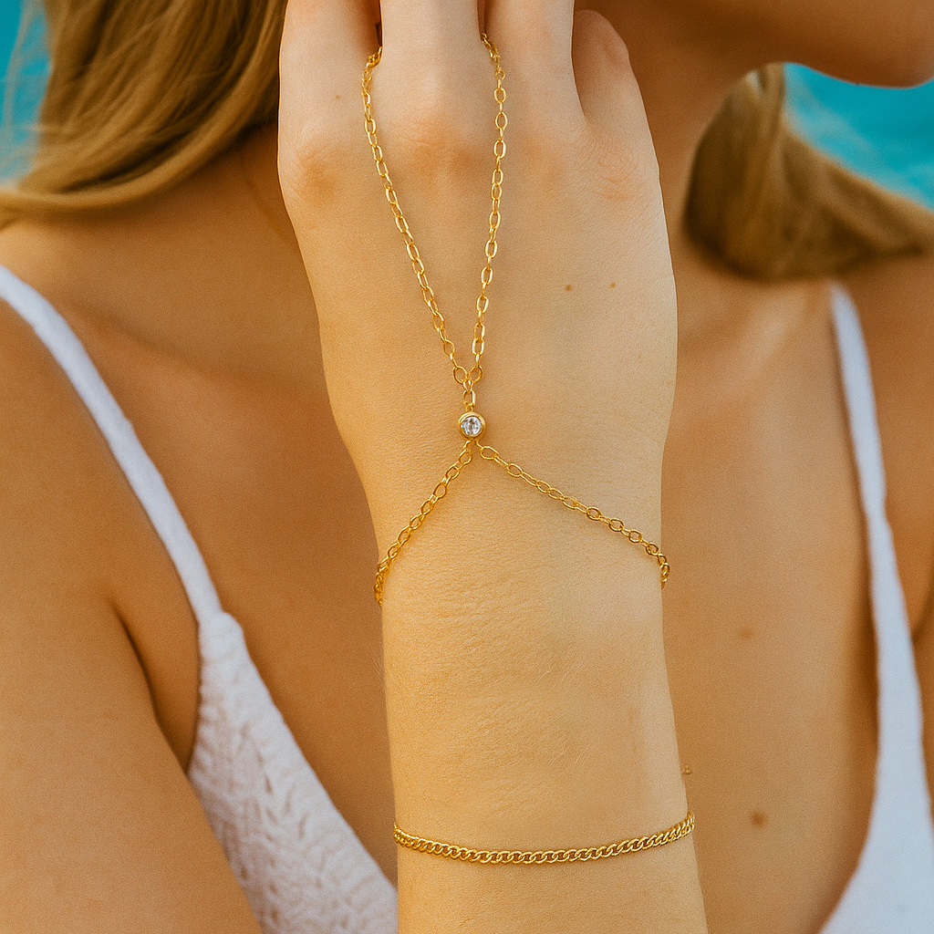 Gold arm chain worn on a hand with a blurred background