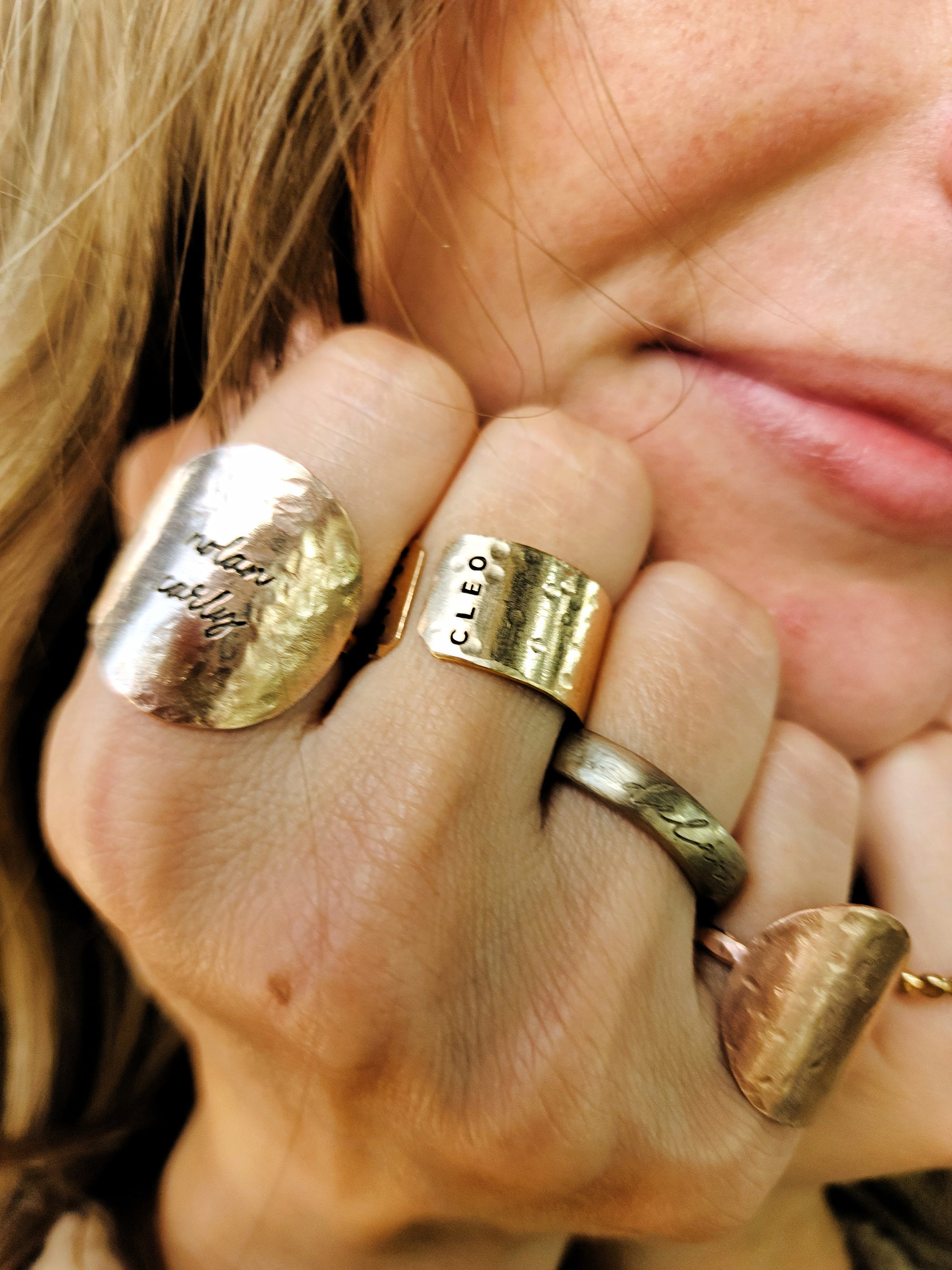 Model wearing multiple 14K gold filled personalized name rings stacked together