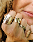 Model wearing multiple 14K gold filled personalized name rings stacked together