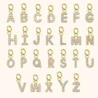 Gold letter pendants with diamonds on a white background