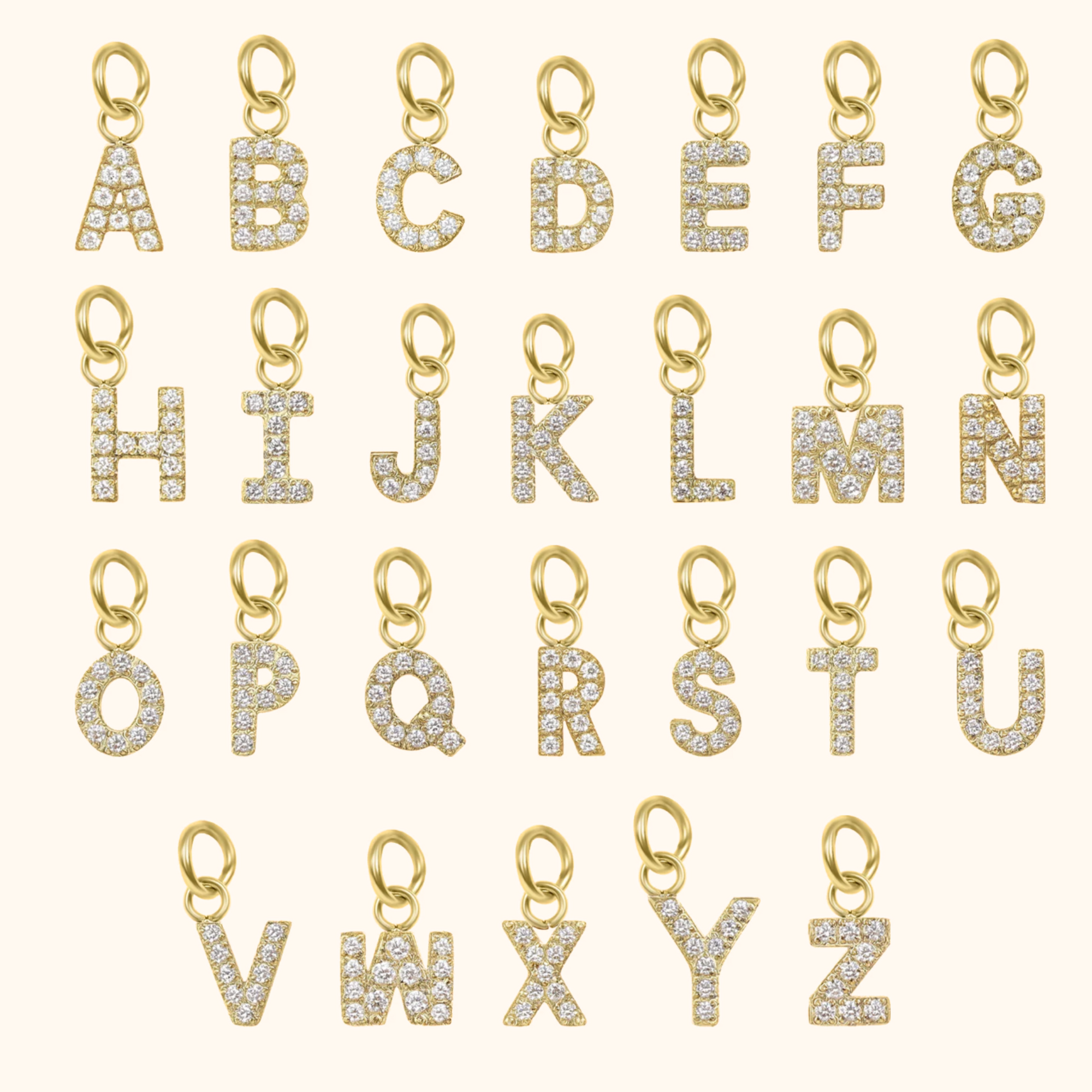 Gold letter pendants with diamonds on a white background