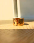 Handcrafted personalized gold name cuff ring photographed in warm studio light