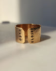 Handcrafted personalized gold name cuff ring photographed in warm studio light