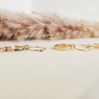 Gold bracelets on a white surface with a fur background