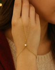 Gold hand chain with a cz on a blurred background