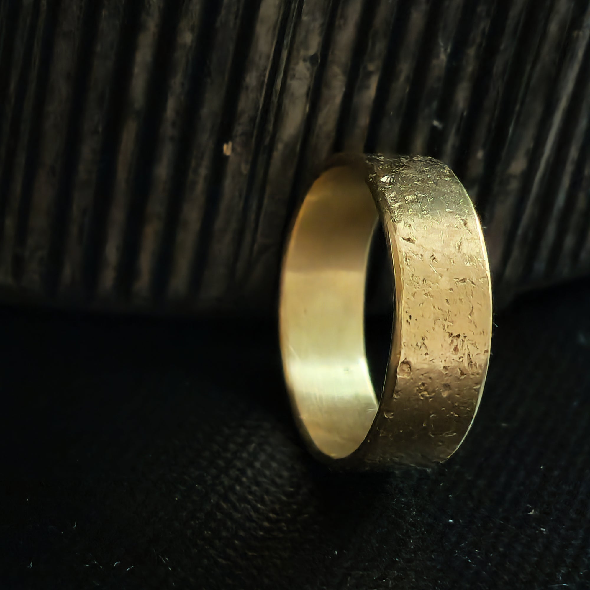 Gold ring on a textured black surface
