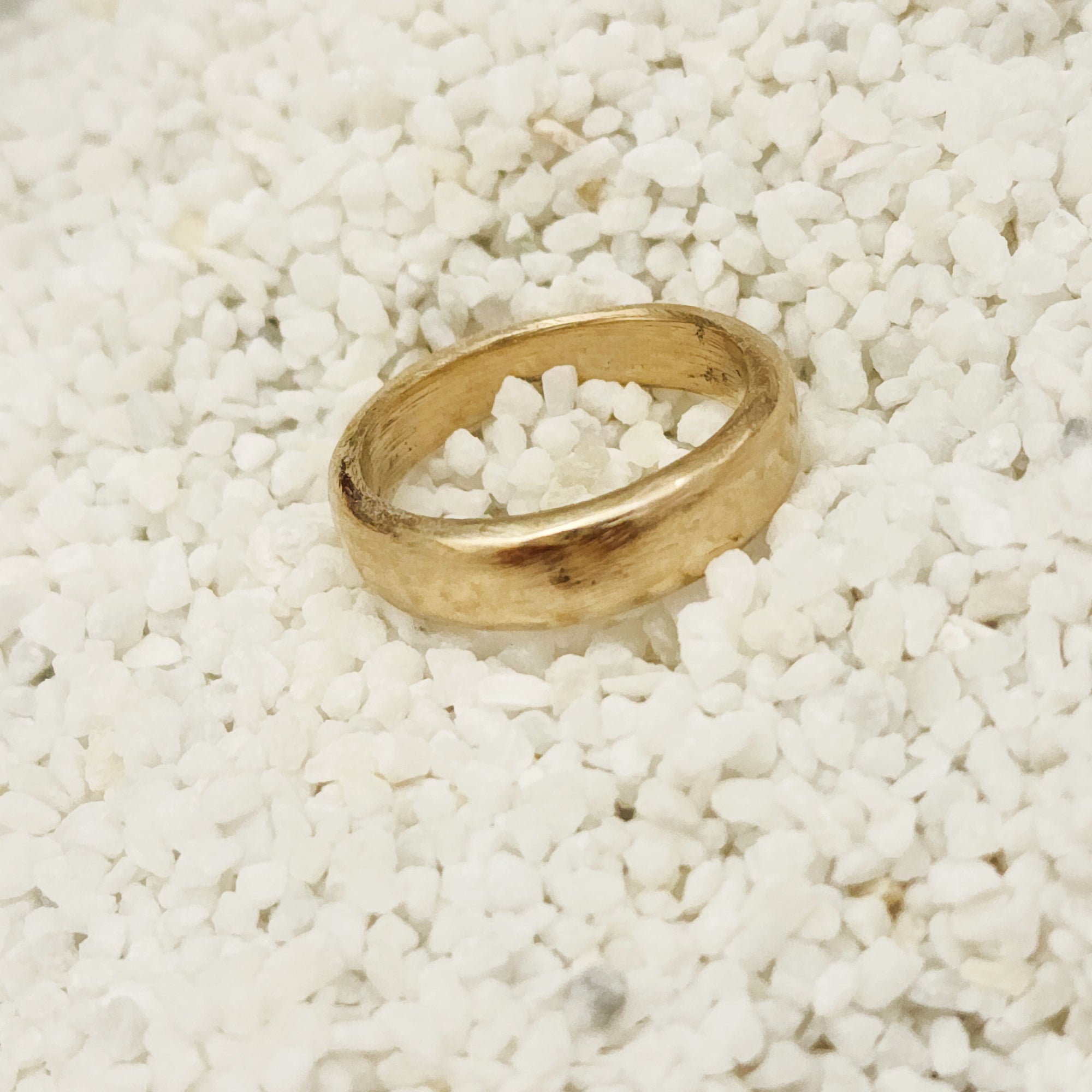 Gold ring on a bed of small white stones