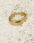 Gold ring on a bed of small white stones