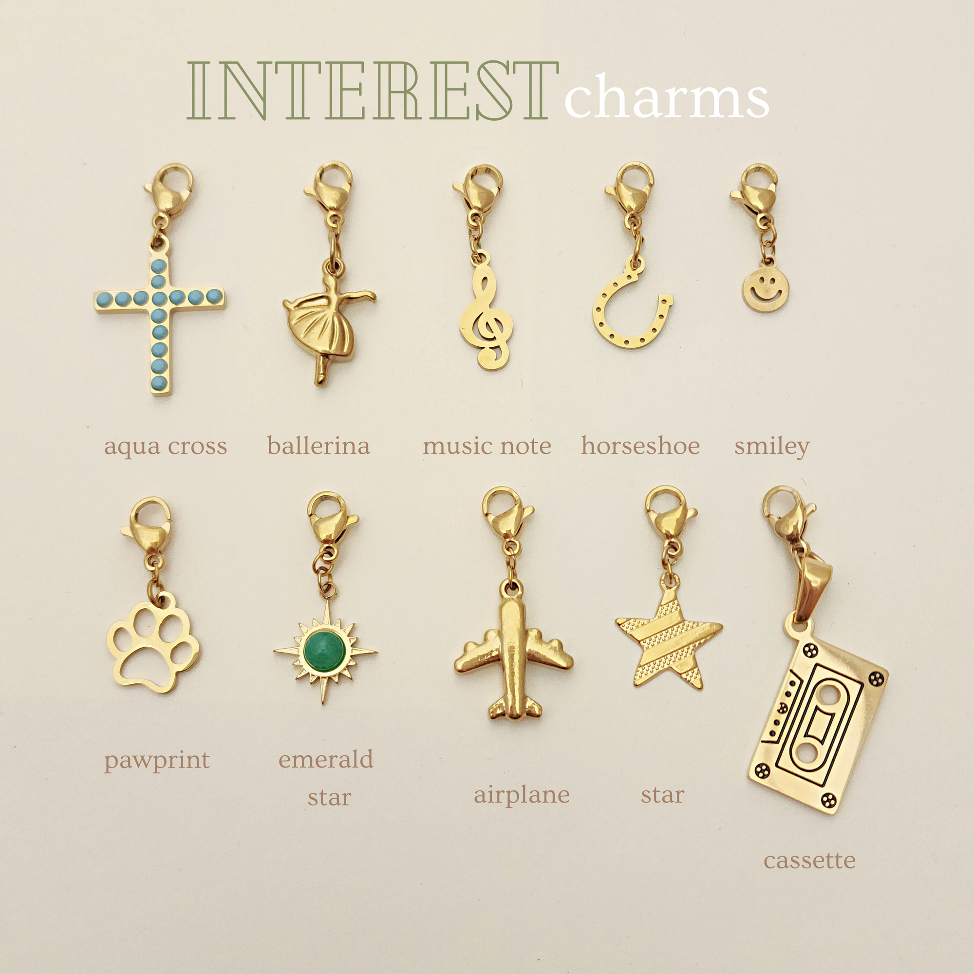 Collection of gold charms with various designs on a beige background