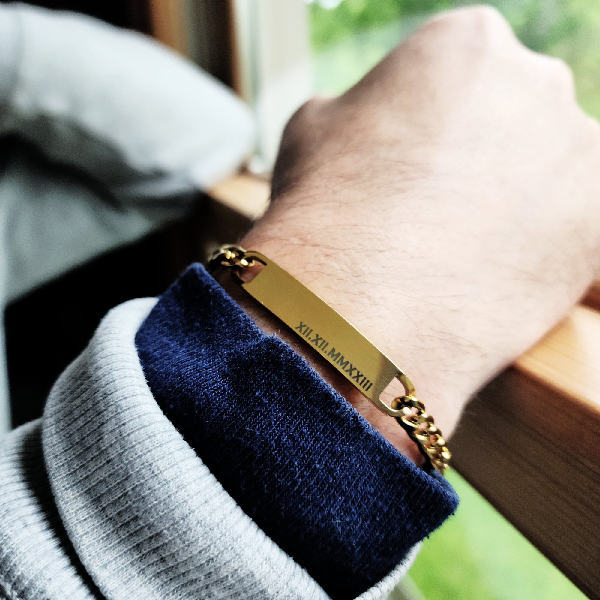 Gold bracelet on a wrist with a blurred background