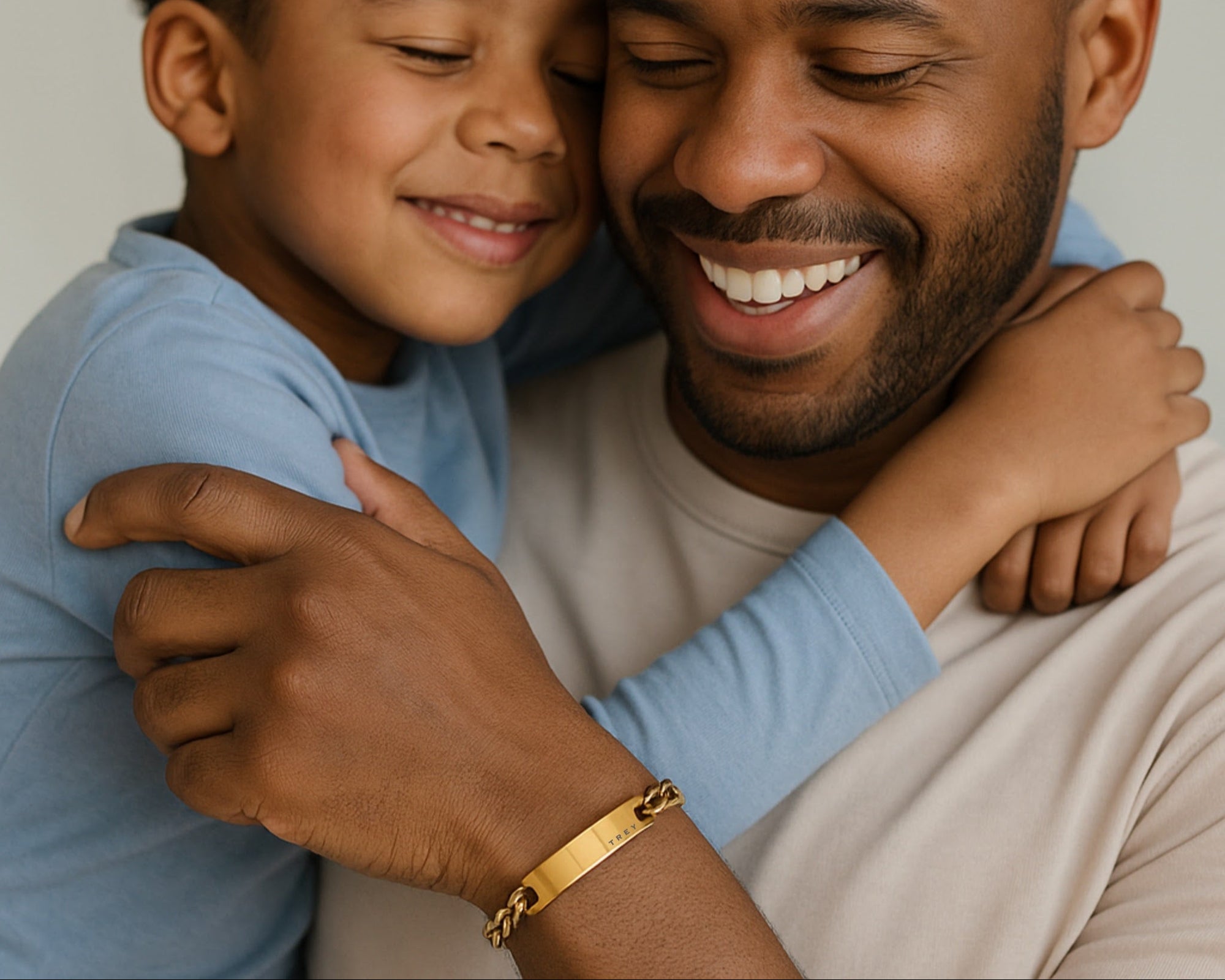 Man and child hugging, both smiling, with a warm and affectionate atmosphere.