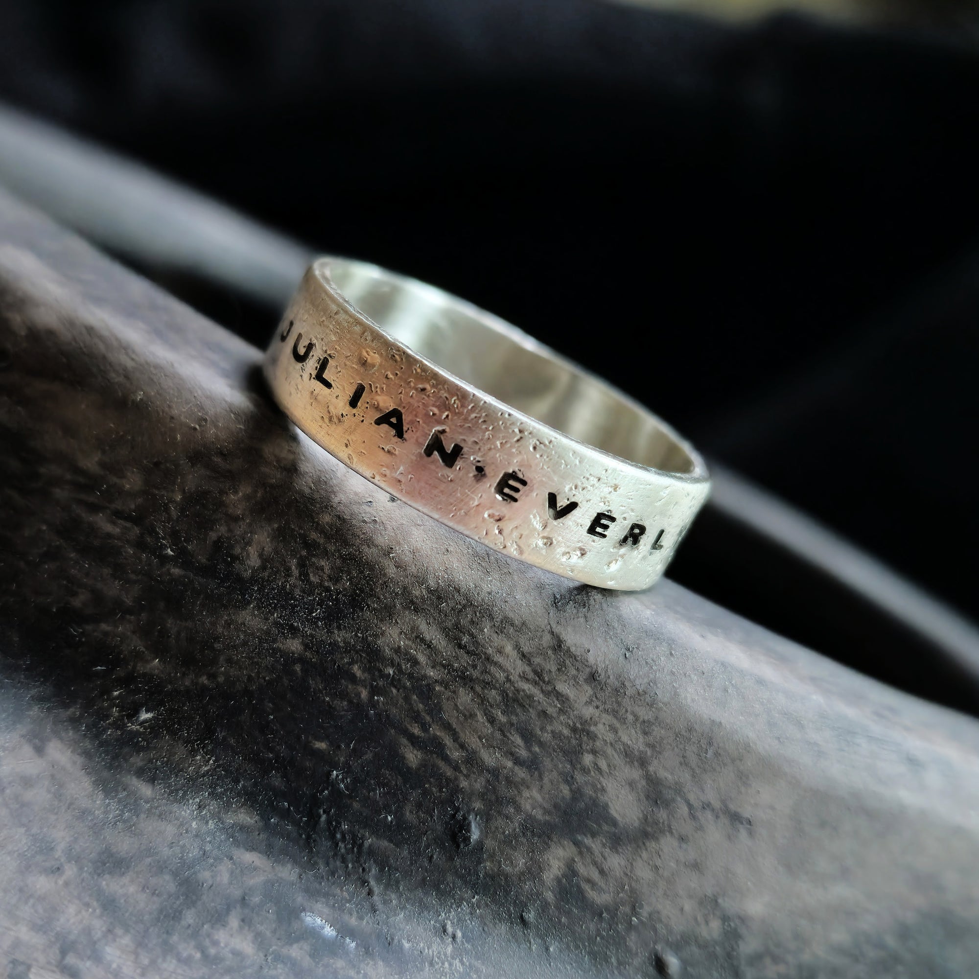 Silver ring with 'JULIAN.EVERLY' engraving on a dark surface