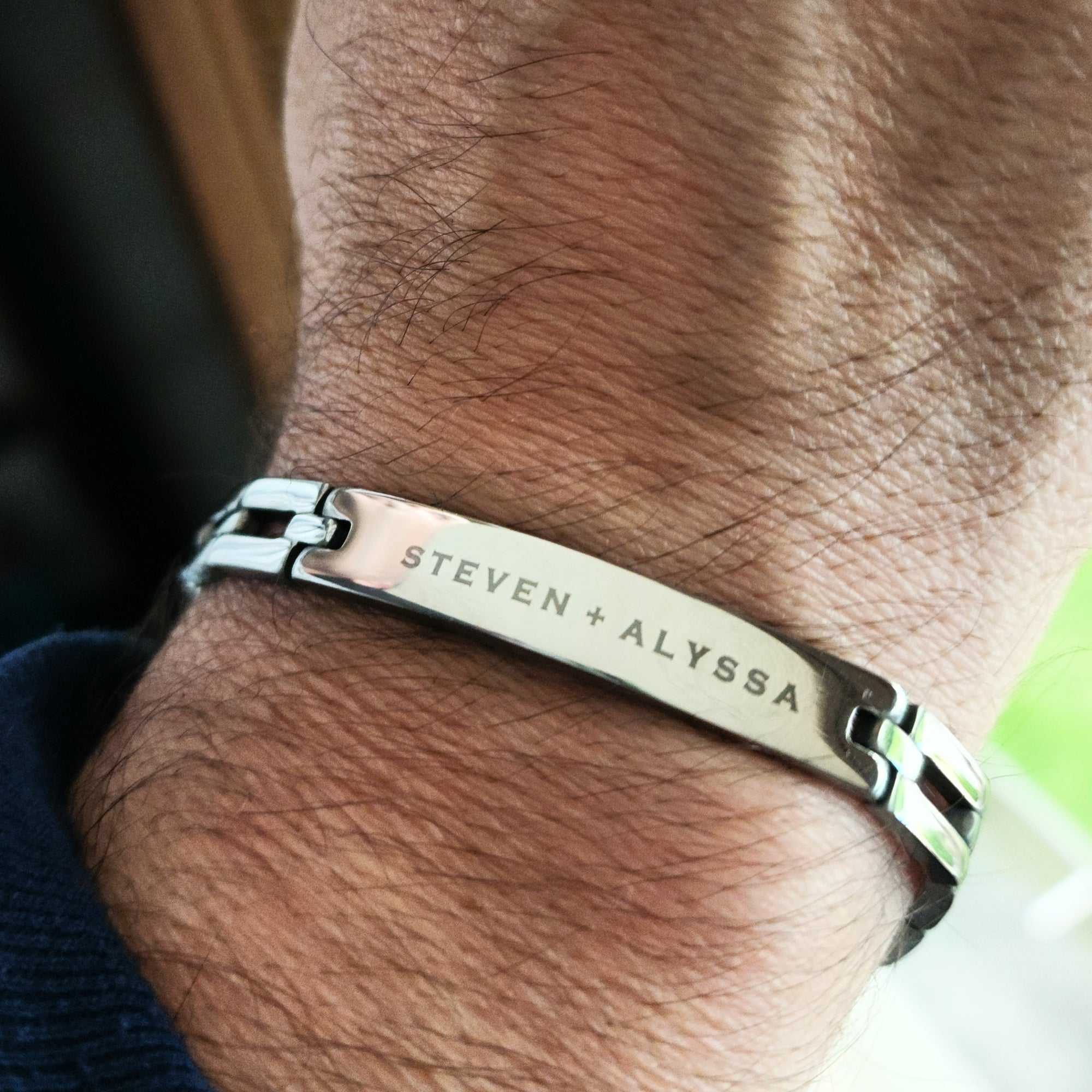 Silver bracelet with engraved names on a wrist