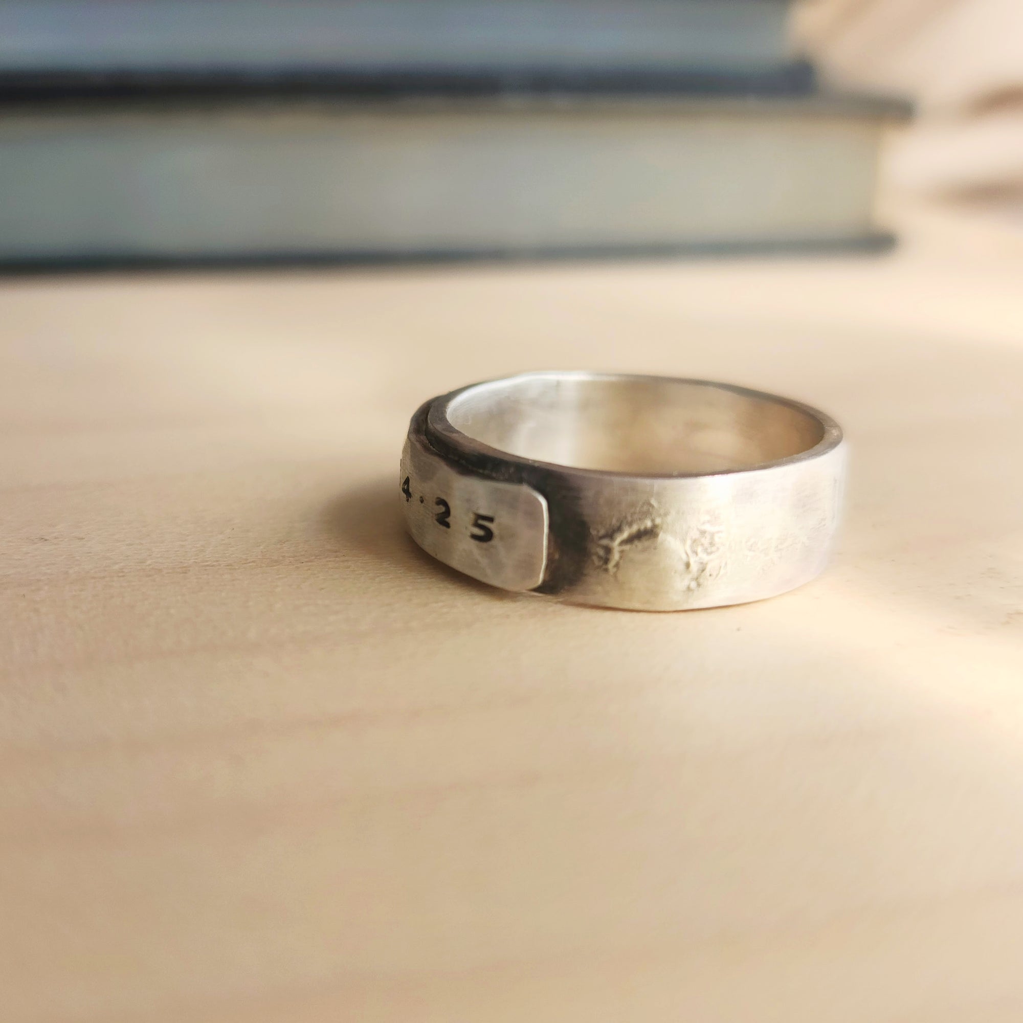 Silver ring with engraved numbers on a wooden surface
