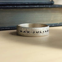 Men’s sterling silver name ring with rugged sandcast texture and oxidized finish, engraved band
