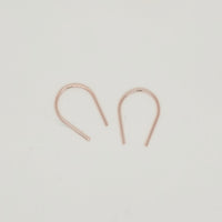 Minimalist gold U-shaped earring pair displayed on white background